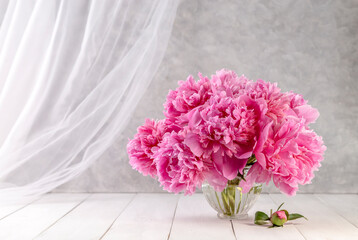 Bouquet of pink peonies in a vase on a wooden table. Gift Valentine's Day