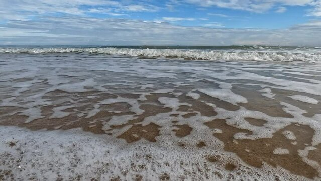 Small calm sea waves at San Juan Playa, beach coastline, low level video Alicante, Spain