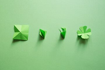 Obraz premium St. patrick's day. green background with clover leave four-leafed. copy space. Paper craft. Step-by-step instructions