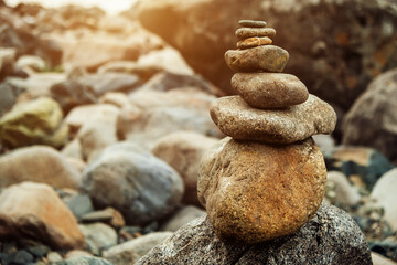 Pyramid of stones in the mountains. Cairn making by tourists. Abstract rock construction.