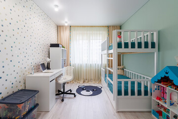 A new modern children's room with a bunk bed with a workplace and wallpaper in multi -colored peas. New house. Inner photo - obrazy, fototapety, plakaty