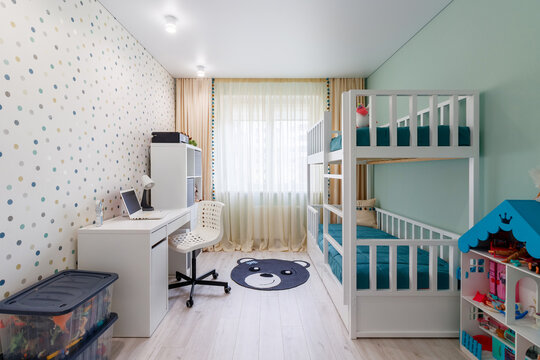 A new modern children's room with a bunk bed with a workplace and wallpaper in multi -colored peas. New house. Inner photo