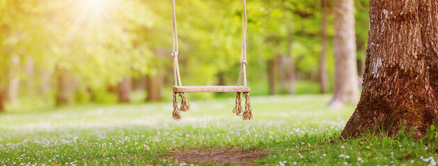 Fototapeta premium Empty swing hanging in the park in spring.