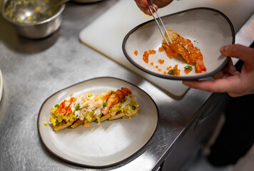 chef cooking brioche with scrambled eggs, caviar and crab meat on kitchen