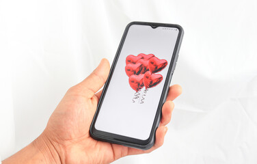 Male hand holding mobile phone with valentine red heart on screen smart phone
