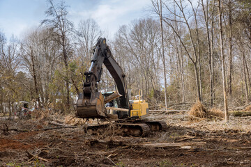 It was necessary to clear land of uprooted trees around subdivision housing development in...