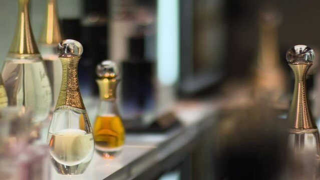 Hand picking up perfume from shop shelf