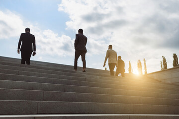 Business people climb the steps of the city stairs. impersonal rising up. Career growth and...