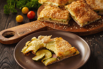 Homemade crispy puff pastry pie with zucchini, ham and mozzarella.