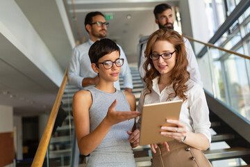 Portrait of two happy success business women talking, having informal meeting in office