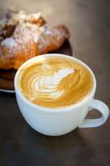 A cup of cappuccino coffee on a table in a cafe. Coffee hot drink in a ceramic cup for breakfast in the morning.