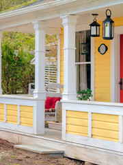 White chair with red pillow on the porch of historical residential house