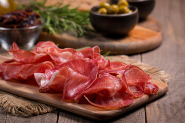 Italian slices of coppa, capocollo, capicollo, bresaola or cured ham with rosemary. Raw food.  