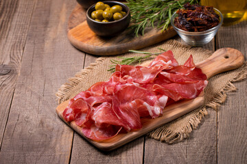 Italian slices of coppa, capocollo, capicollo, bresaola or cured ham with rosemary. Raw food.   - obrazy, fototapety, plakaty
