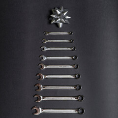 Christmas tree made of wrenches on black background. Tools spanners. Technique repair, equipment for mechanical service, labor's holiday concept. Chrismas or New year concept. Flat lay, top view