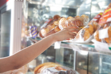 Obraz premium Woman choosing sweets in supermarket.