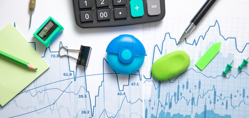 Calculator and other items with a financial graphs.