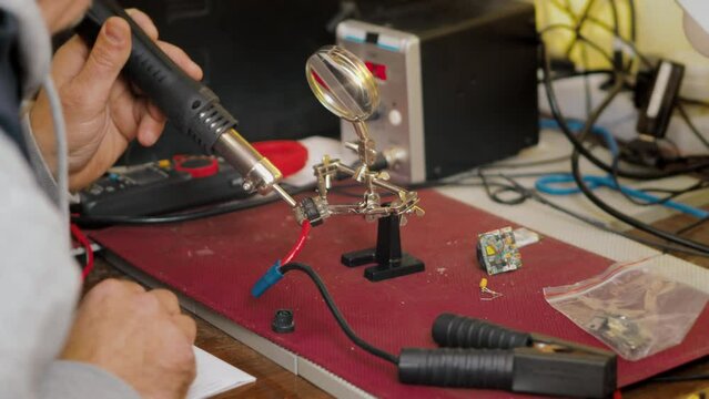 Electronics repair and small business at home. Soldering a circuit using a soldering hair dryer hot Air Soldering Iron.
