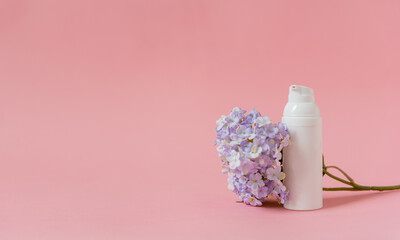 Mockup cosmétique sur fond rose avec fleur mauve