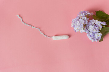 Tampon et fleur mauve sur fond rose