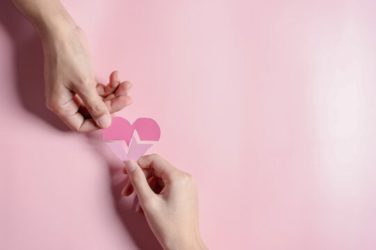 Hands holding pink heart donation concept, health care, organ donation, family life insurance, world heart day, world health day, praying concept
