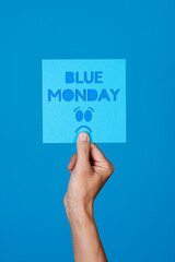 holds a sign with the text blue monday
