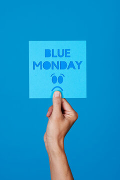 holds a sign with the text blue monday
