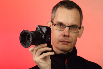 Fototapeta premium a young person takes a photo with a digital SLR camera with an old lens