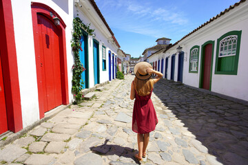 Holidays in Paraty, Brazil. Back view of beautiful fashion girl enjoying visiting historic town of Paraty, Rio de janeiro. Summer vacation in Brazil.