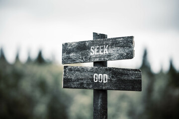 vintage and rustic wooden signpost with the weathered text quote seek god, outdoors in nature. blurred out forest fall colors in the background. - 559792355