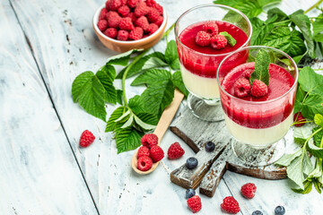 Italian dessert. Raspberry Panna cotta with raspberry jelly on a light background. Berry dessert with cream sauce in small jars. Long banner format. place for text