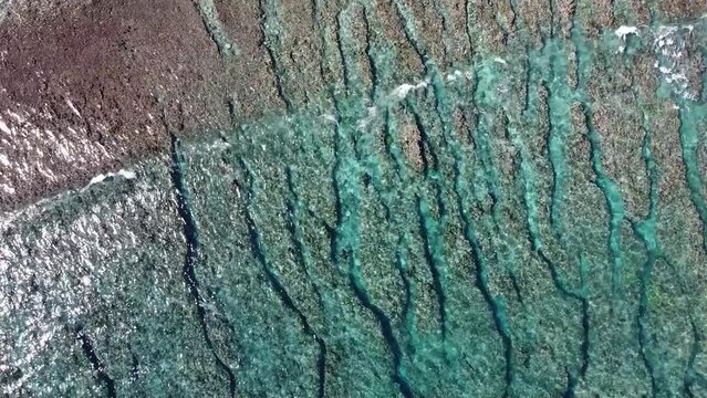 Oc&eacute;an indien film&eacute; par drone sur l'&icirc;le de la R&eacute;union. Coraux et eau bleu turquoise transparente avec vague et houle sur le sable de la plage.