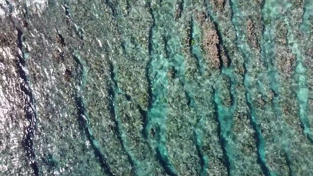 Oc&eacute;an indien film&eacute; par drone sur l'&icirc;le de la R&eacute;union. Coraux et eau bleu turquoise transparente avec vague et houle sur le sable de la plage.