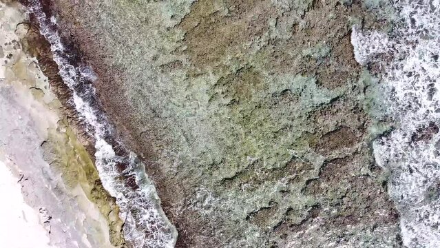 Oc&eacute;an indien film&eacute; par drone sur l'&icirc;le de la R&eacute;union. Coraux et eau bleu turquoise transparente avec vague et houle sur le sable de la plage.