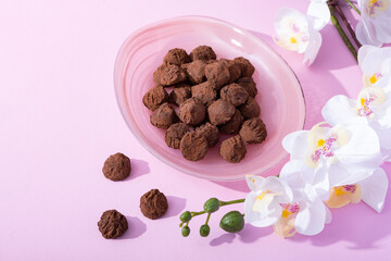 Handmade rustic chocolate truffles with white orchid flowers on pink