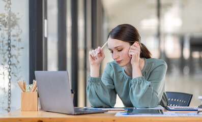 Portrait of tired young business Canada american woman work with documents tax laptop computer in office. Sad, unhappy, Worried, Depression, or employee life stress concept	