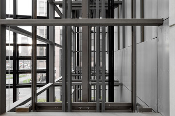 Selective focus view at open system and modern industrial style of elevator with steel cage grid frame structure.