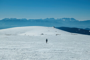 Woman hiking in snow covered landscape near Ladinger Spitz, Saualpe, Lavanttal Alps, Carinthia,...