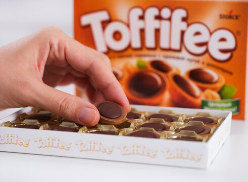 Tambov, Russian Federation - December 29, 2022 A woman hand taking Toffifee candy from open candies box.