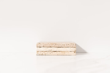 Mockup product presentation podium made with travertine tiles on white background. Front view.