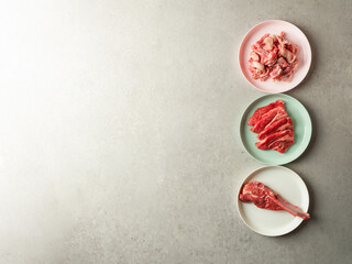 Variety of raw meat and lamb on colorful plates