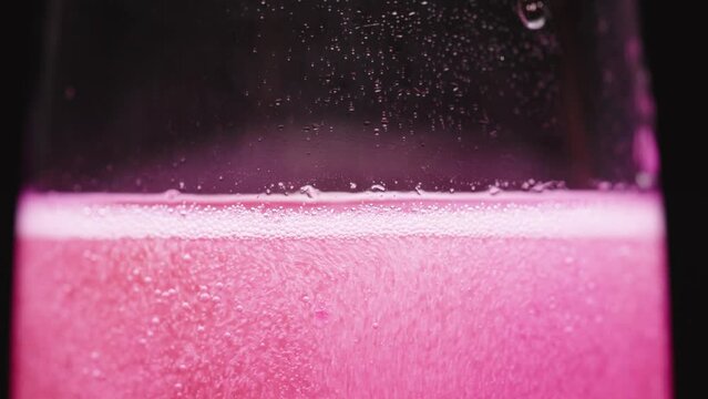 I throw pink cotton candy into a glass of champagne, a sweet cocktail, a close-up.