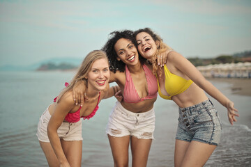 portrait of three young smiling women at the beach