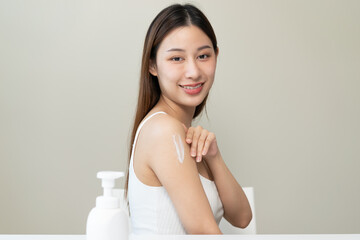 Body skin care routine concept. young asian woman applying lotion cream on the shoulder