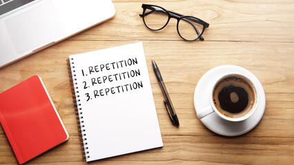Repetition, motivational words and sentences for work and life. Quote sentence in notebook with laptop, pen, coffee over wooden background.
