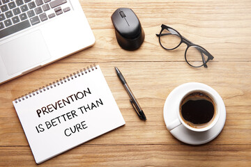Prevention Is Better Than Cure, motivational words and sentences for work and life. Quote sentence in notebook with laptop, pen, coffee over wooden background.