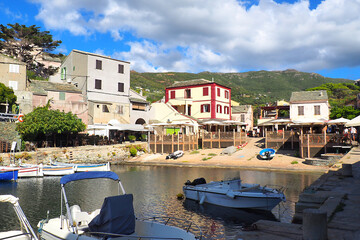 Fototapeta na wymiar With its fishing port and its colorful marina thanks to the multicolored nets of the fishermen who perpetuate the tradition of lobster fishing, Centuri is one of the most picturesque in Corsica