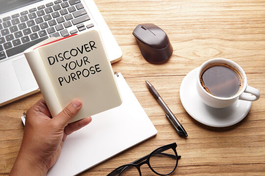 Discover Your Purpose, motivational words and sentences for work and life. Quote sentence in notebook with laptop, pen, coffee over wooden background.