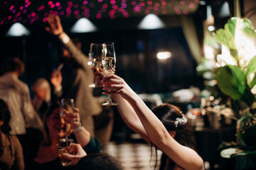 people, celebration, party, holidays and drink concept-close up of woman hands holding champagne at restaurant