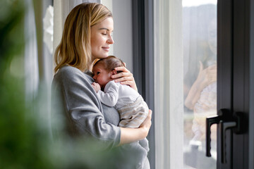 Loving mother hugs her little baby at home - 559825196